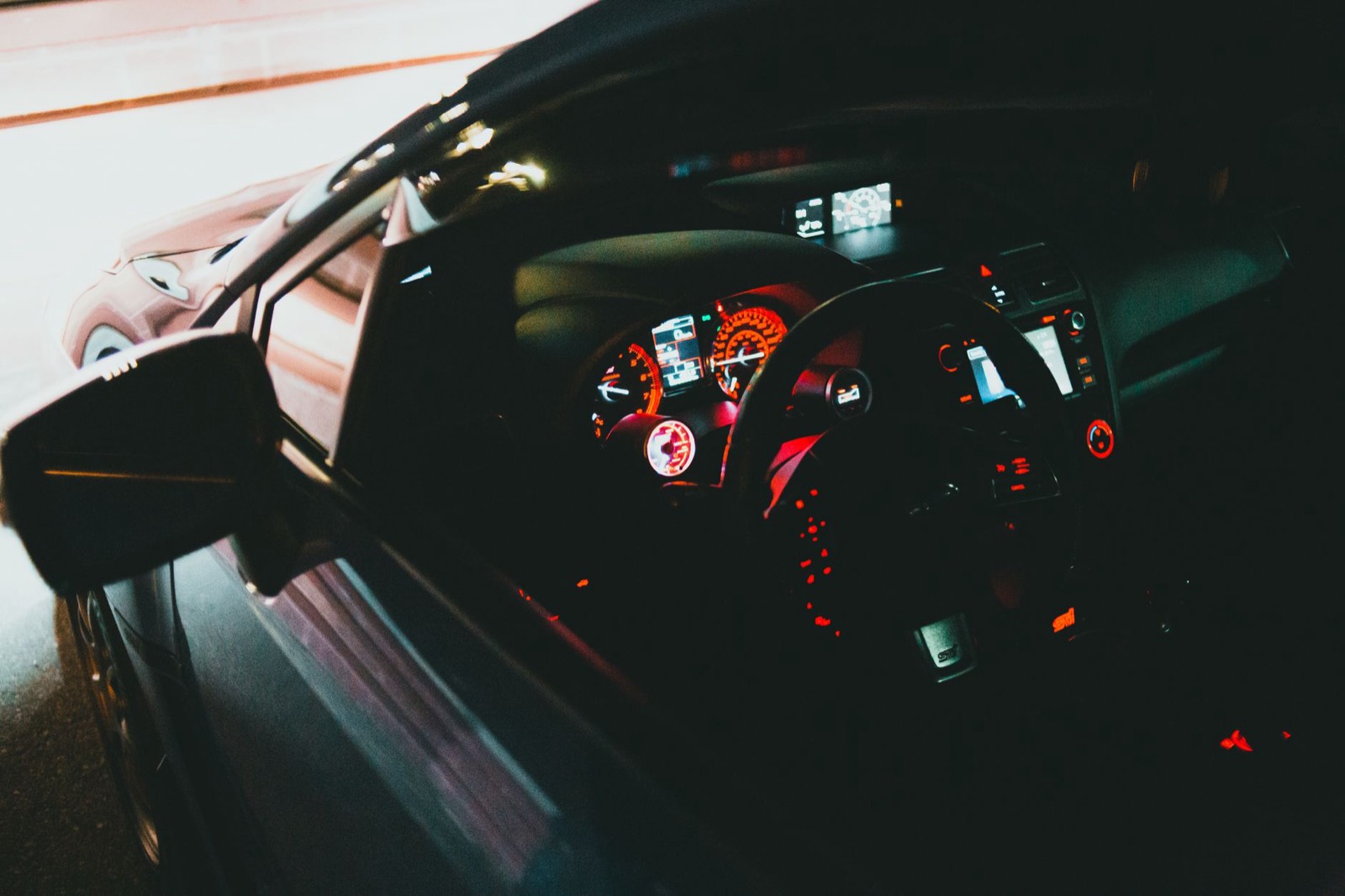 Tableau de bord d'une voiture de nuit, zone où un traceur GPS peut être dissimulé