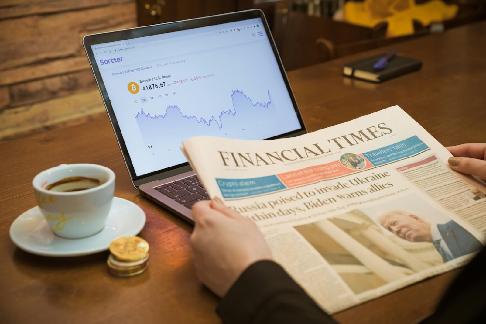 Journal financier, tasse de café et tablette affichant des cours de Bourse sur une table